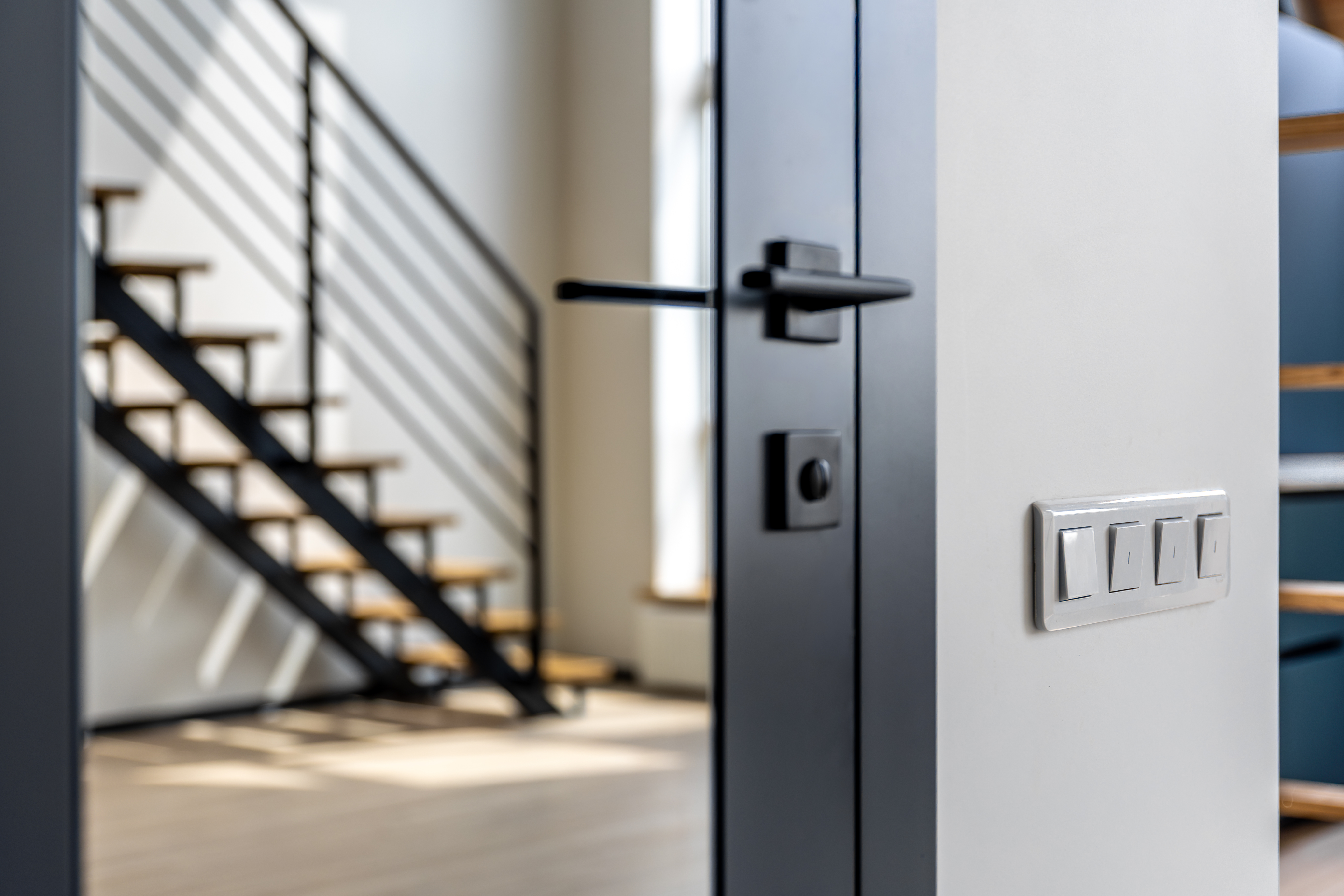 Light switches near metal door handle and stairs lighting control